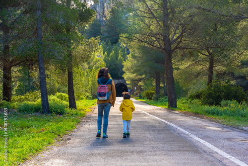 Mother and child walking on a scenic road in la fontcalda sanctuary, gandesa, tarragona