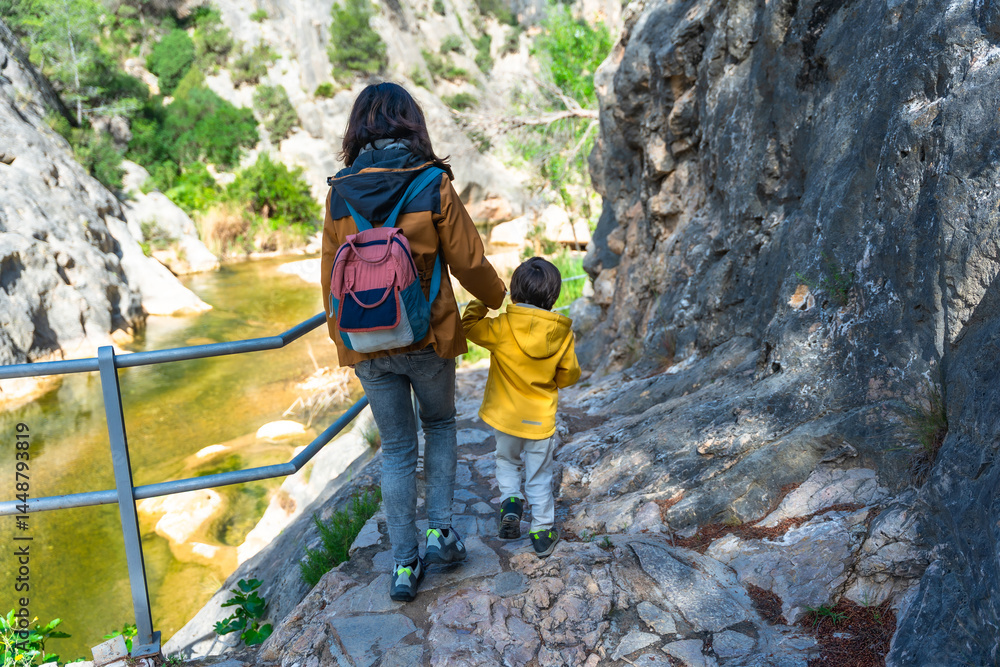 Mother and son hiking along canaletes river in la fontcalda sanctuary, gandesa, tarragona