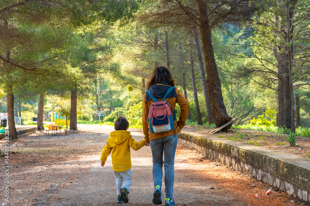 Mother and son walking on a path at la fontcalda sanctuary in gandesa, tarragona