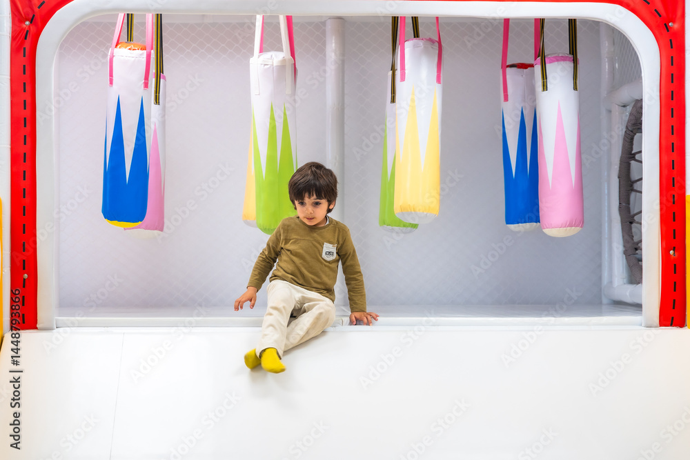 Toddler sitting and playing in soft indoor playground structure