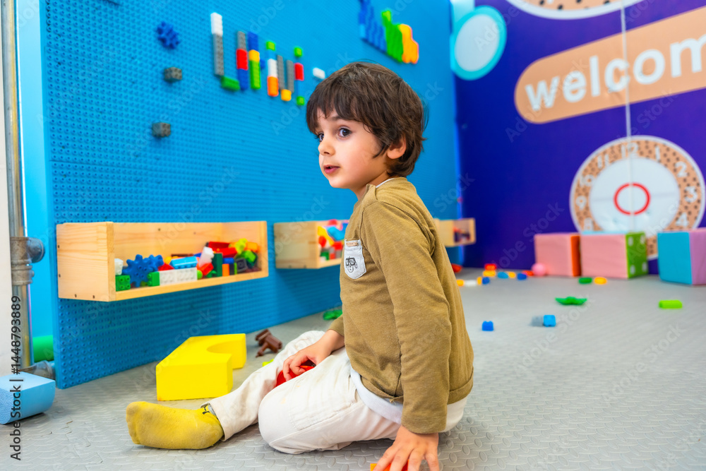 Child playing with construction toys in playroom developing creativity