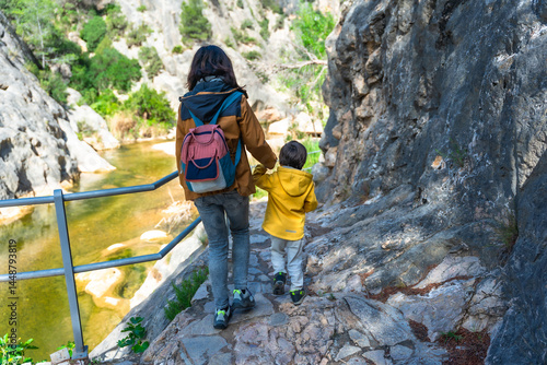 Obraz na płótnie Mother and son hiking along canaletes river in la fontcalda sanctuary, gandesa, tarragona w salonie