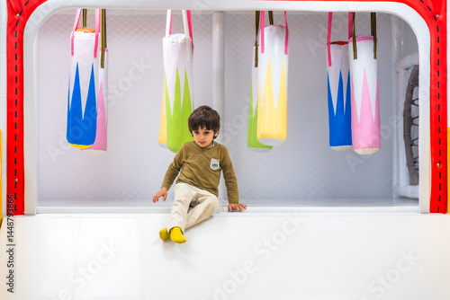 Toddler sitting and playing in soft indoor playground structure