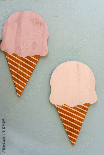 Obraz na płótnie Two decorative wooden ice cream cones hanging on a light blue wall w salonie