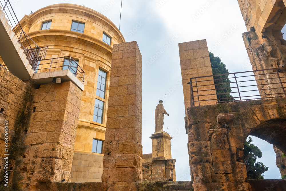 Statue overlooking ancient roman ruins in tarragona, spain