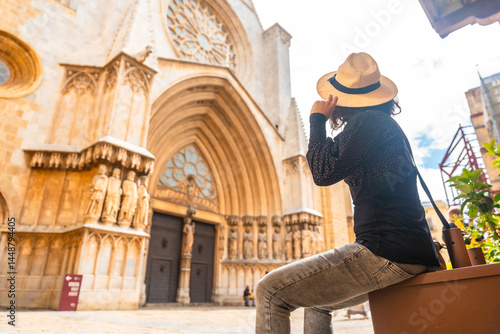 Obraz na płótnie Tourist holding her hat while admiring tarragona cathedral in spain w salonie