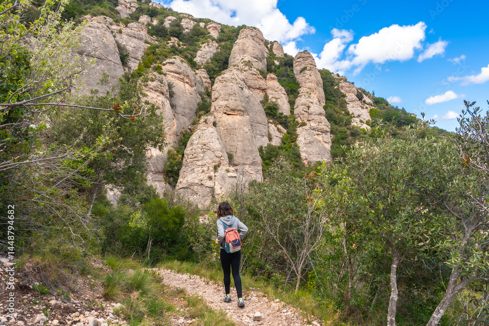 Tourist walking on a path in montserrat mountains near barcelona, catalonia, spain