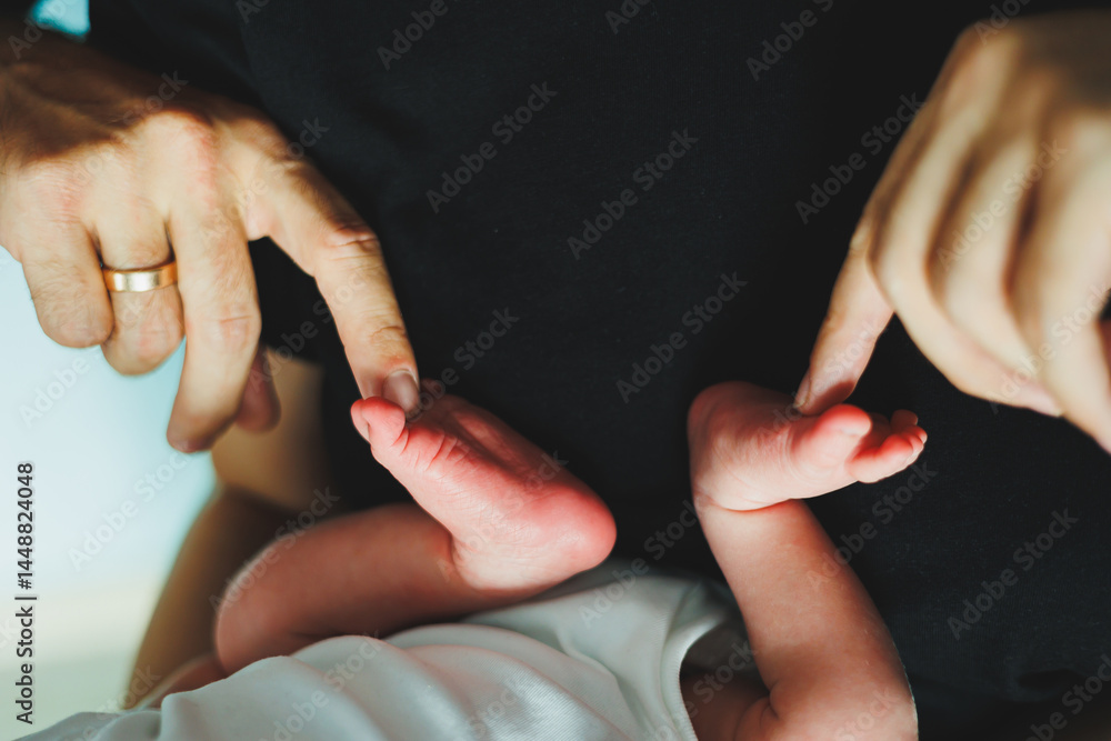 Close-up of baby feet in parent's hands. Baby feet with little toes. Cute photo of baby feet.