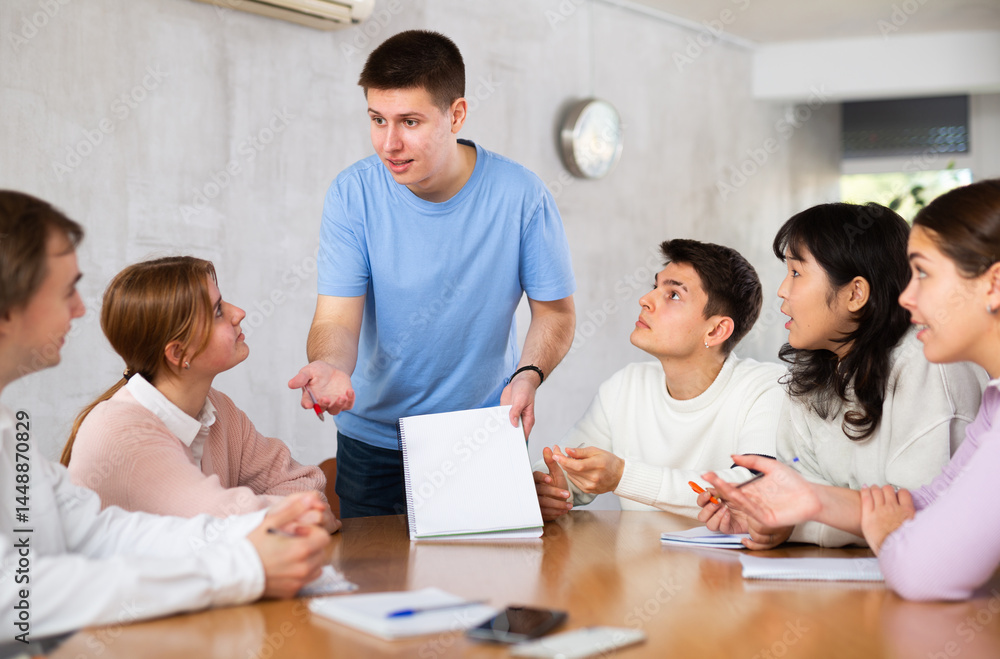 Young male professor explaining subject to group of students Young male professor explaining subject to group of students