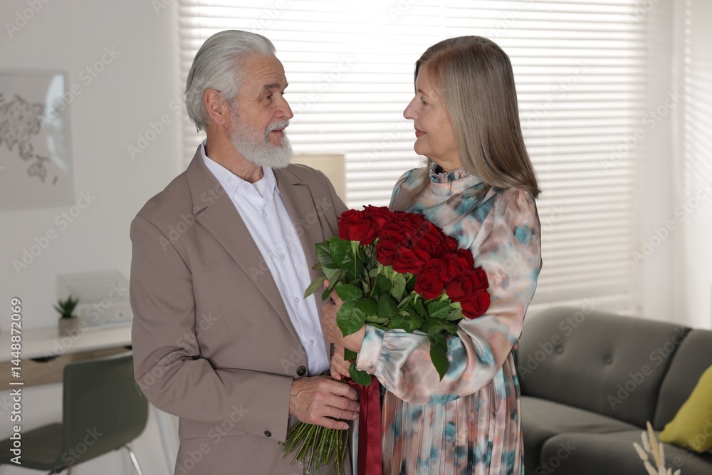 Cute couple with bouquet of red roses at home Cute couple with bouquet of red roses at home