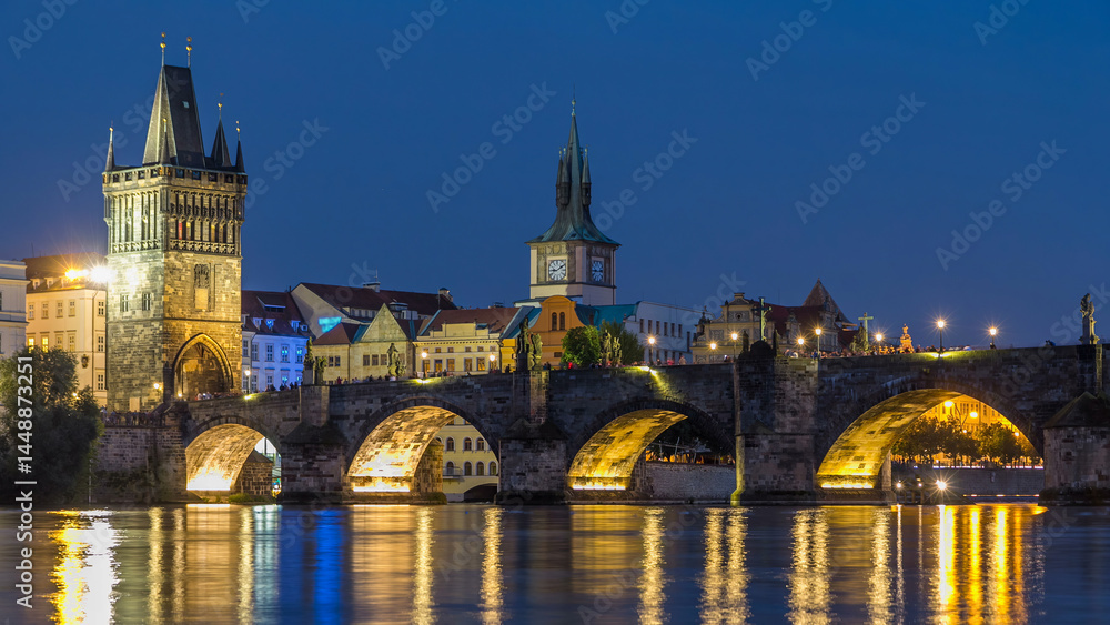 The Charles Bridge day to night timelapse over the Vltava River reflected in water in Prague, Czech Republic The Charles Bridge day to night timelapse over the Vltava River reflected in water in Prague, Czech Republic