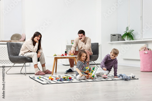 Overwhelmed parents looking at their hyperactive children at home