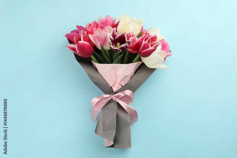 Naklejka premium Bouquet of beautiful tulips on light blue background, top view