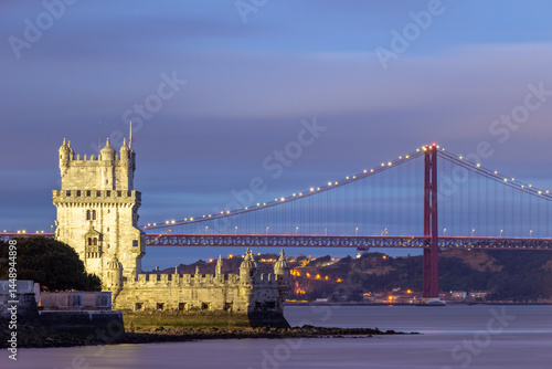 Illuminated Belem Tower, 25th of April Suspension Bridge and Tagus River at Night. Lisbon, Portugal. Blue Hour