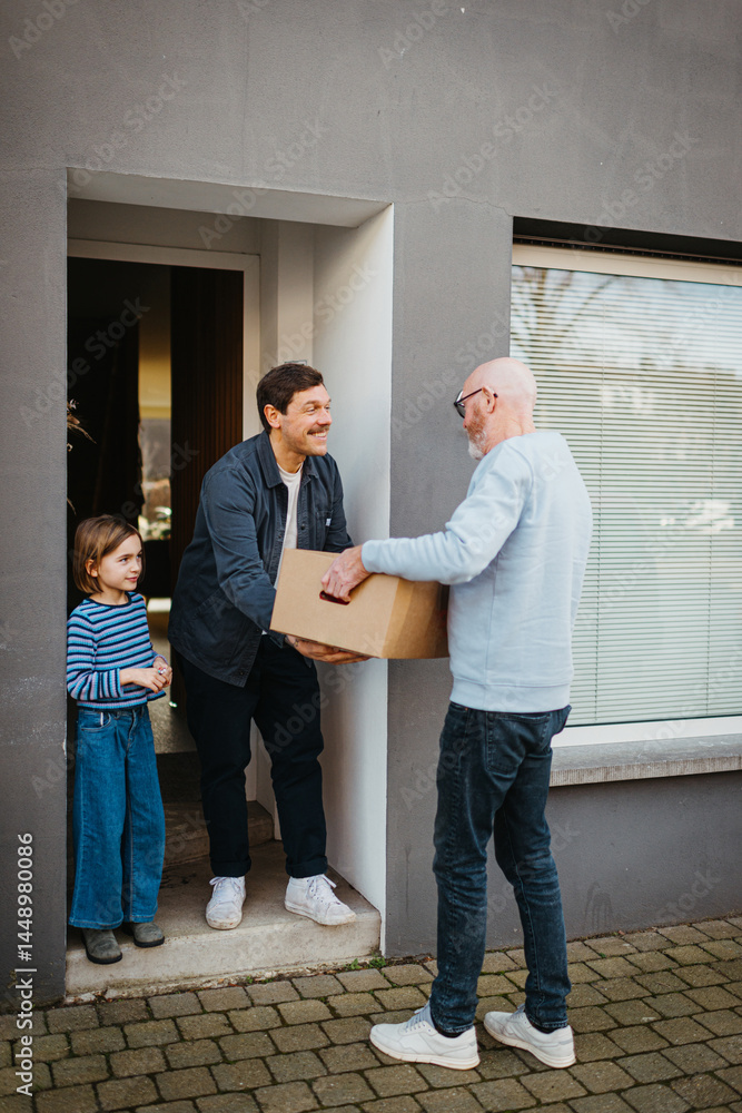 delivery man handing over package to happy family at door delivery man handing over package to happy family at door