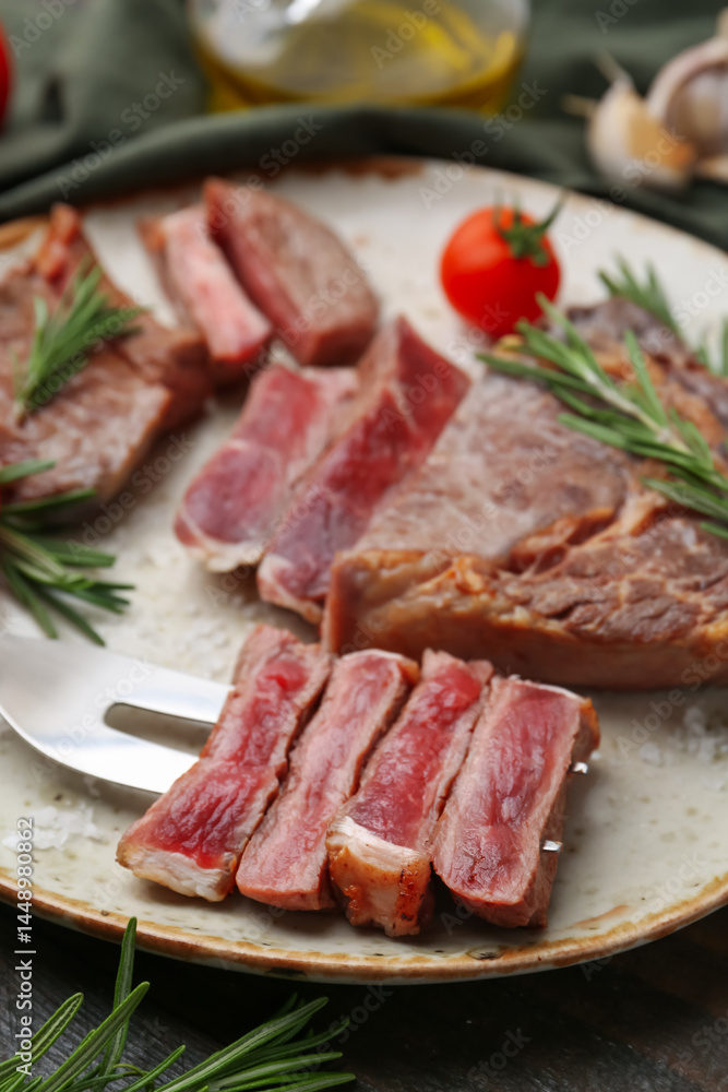 Pieces of delicious beef meat, spices and tomato on table, closeup Pieces of delicious beef meat, spices and tomato on table, closeup