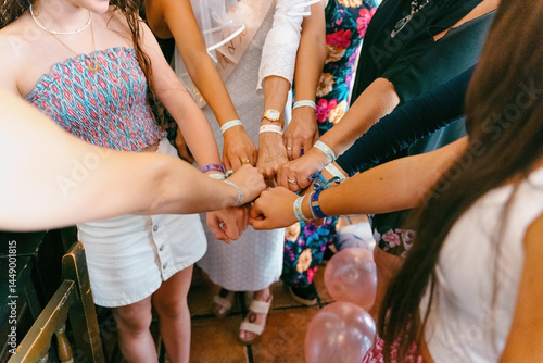Women wearing matching bracelets at a  party. 