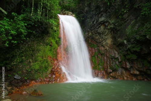 Tranquil Waterfall in Lush Tropical Greenery with Vibrant Rock Formations
