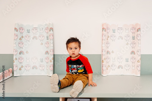 Little boy sitting at a changing station at daycare