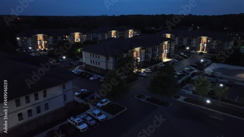 Wallpaper Mural Evening scene in new build american townhouse neighborhood. Lighting facade of homes and parking cars on lot. Aerial approaching shot. American city suburb in Virginia. Torontodigital.ca