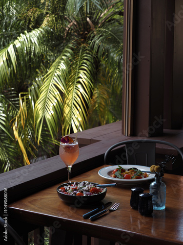Canvas Print Tropical Cocktail and Meal on Table Beside Palm Leaves