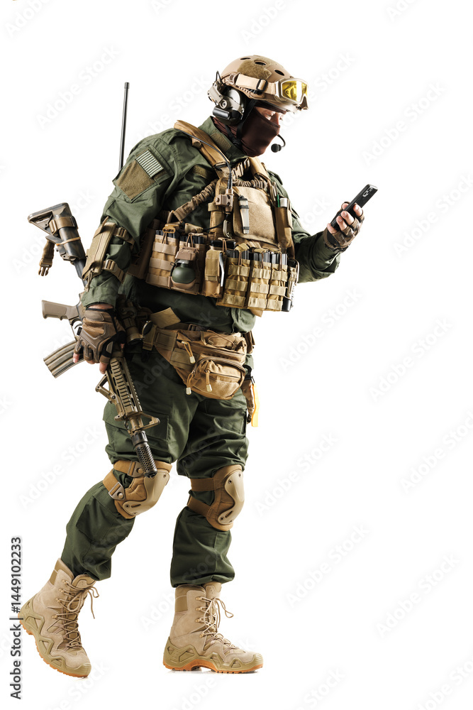 Tactical Soldier in Full Gear Using Handheld Device in Isolated Setting Tactical Soldier in Full Gear Using Handheld Device in Isolated Setting