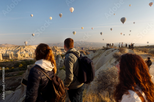 a group of young people admire hot air balloons