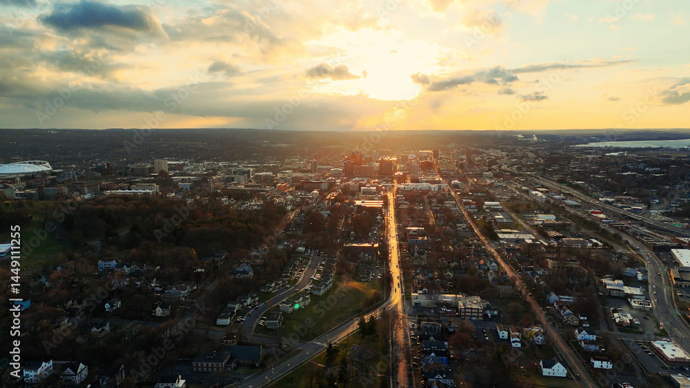 Fototapeta premium Aerial View of the Syracuse City Skyline and the network of it's roads as the sun begins to set over it.