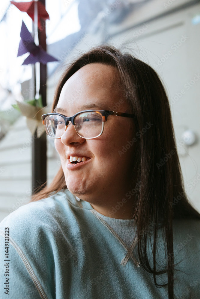 Smiling Individual Near Window with Origami Decor in Soft Lighting Smiling Individual Near Window with Origami Decor in Soft Lighting