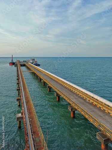 Wallpaper Mural A majestic jetty of a coal-fired power plant stretches boldly into the blue sea, like a bridge between humankind and energy. Its steel pillars stand firm, silent witnesses to the rhythm of industry Torontodigital.ca