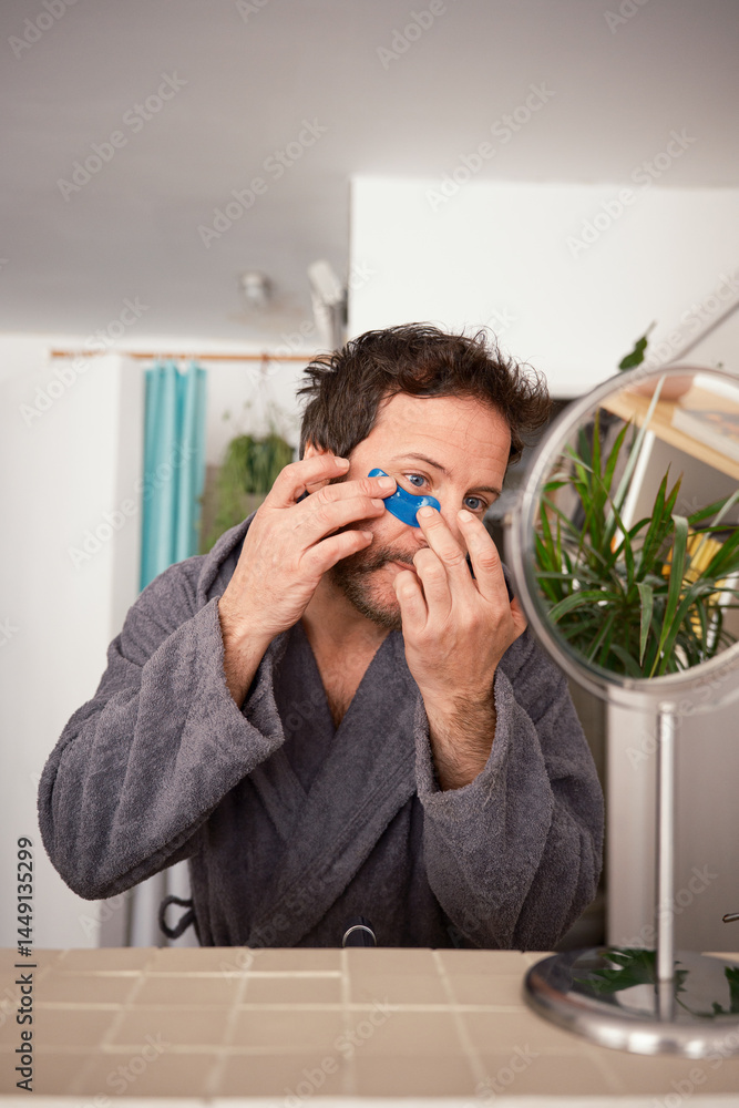 Man applying eye patches Man applying eye patches