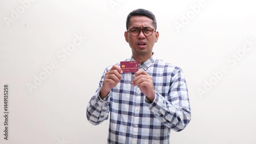 Man showing confused and sad expression while holding credit card