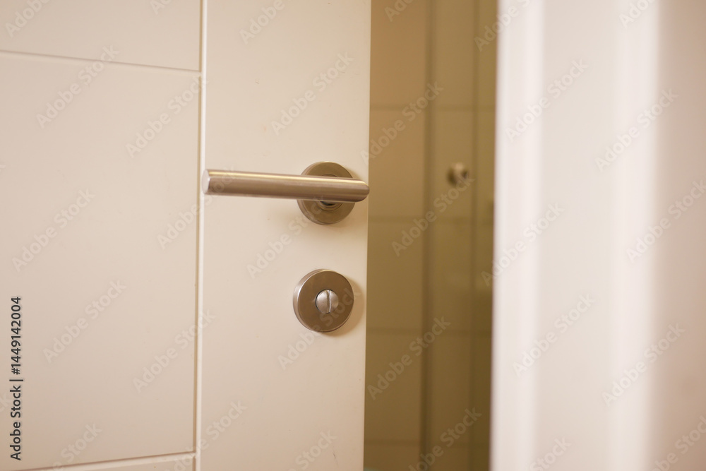 Door opening to reveal a modern bathroom in a home setting Door opening to reveal a modern bathroom in a home setting