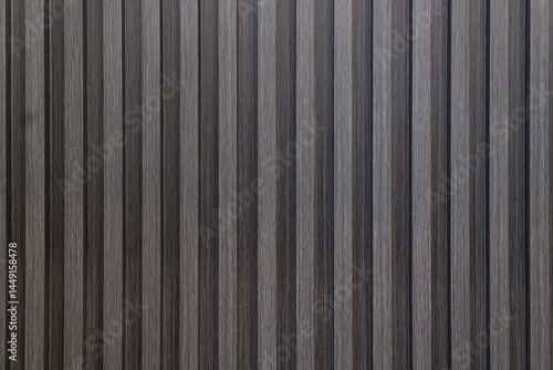 Close-up texture of dark wood wall paneling. Features vertical wooden slats creating a rhythmic pattern with visible grain. Ideal backdrop or surface detail