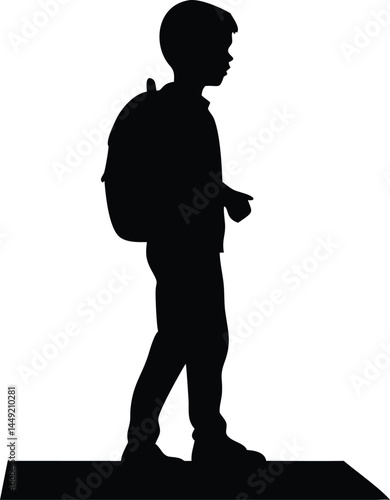 Side view silhouette shows a young boy walking with a backpack to school