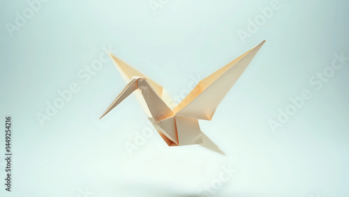A delicate origami crane gracefully suspended in mid-air against a soft, light blue background