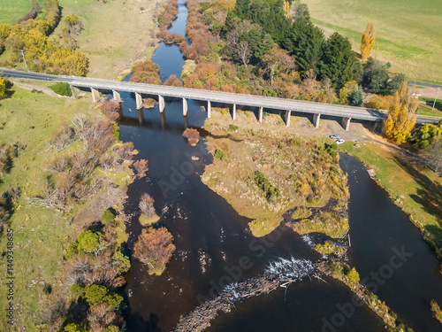 Bridge over inland river surrounded by Autumn foliage