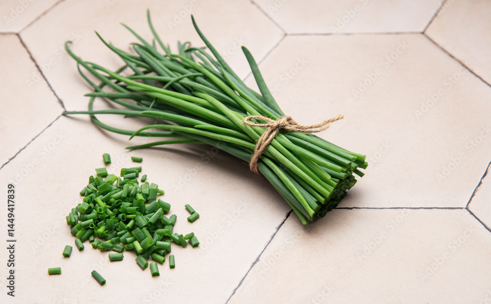 Freshly cut chives tied with twine on a tiled surface