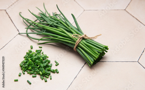 Obraz na płótnie Freshly cut chives tied with twine on a tiled surface w salonie