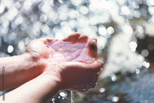 Clear and clean spring water in your hand, the water of life background
