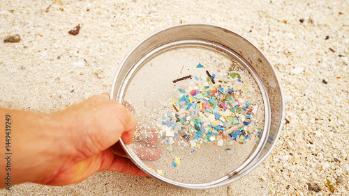 Obraz na plátně Collected microplastic fragments in a sieve show marine debris, rubbish on shore