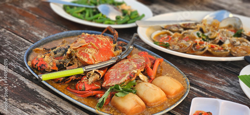Photography Chilli crab Singapore style serving with fried bun on the timber table