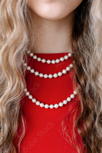 Multiple strands of pearls create an elegant look against a red dress
