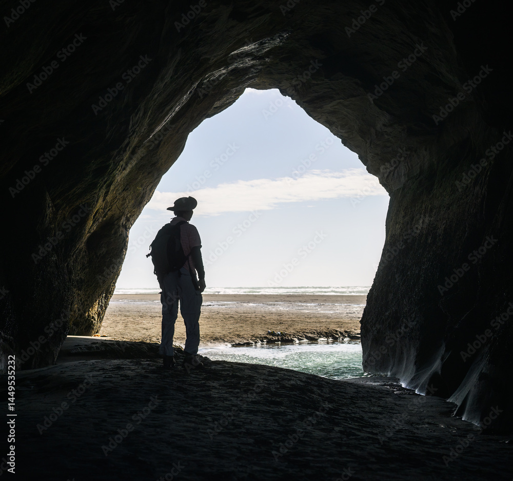 Man in silhouette standing in the cave at Tongaporutu. Taranaki. New Zealand.