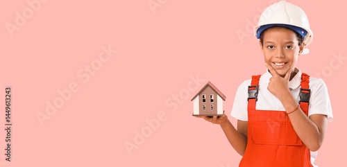 Thoughtful little African-American architect with house model on pink backgro...