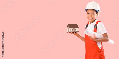 Little African-American architect with house model and blueprint on pink back...