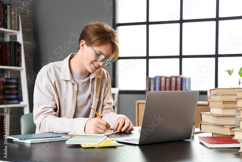 Male student studying at ta...