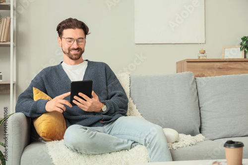 Young man with e-reader sit...
