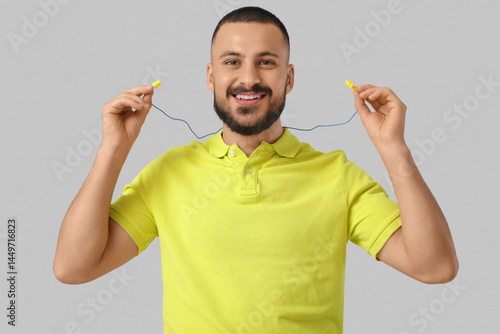 Young man with earplugs on ...