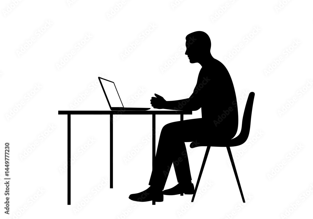 Fototapeta premium Silhouette of a Man Working on Laptop at Desk